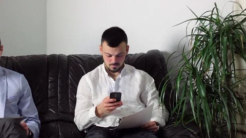 Two guys in a waiting room, waiting for an appointment Stock Footage 72351332