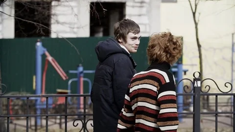 Two guys in warm clothes walking down street talking and laughing Stock Footage 84931598