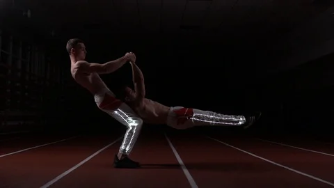 Two gymnasts and acrobats perform horizontal power stance Stock Footage 129472828