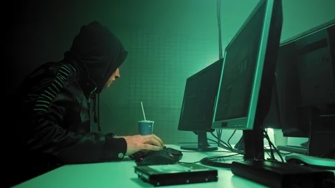Two hackers in hoods work on a computers with maps and data on display screens Stock Footage 111287271