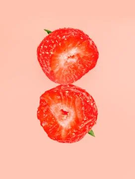 Two half bit strawberrys isolated on red pastel background. March 8 card concept Stock Photos