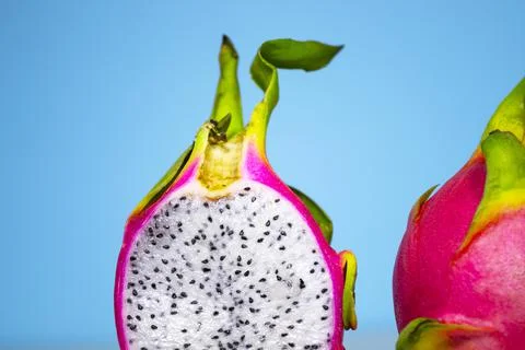Two Half of Fresh organic Dragon Fruit on a blue background, creative summer Stock Photos
