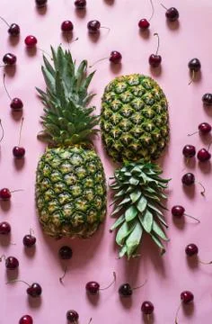 Two half of fresh upside down pineapple on pink background with cherry Stock Photos