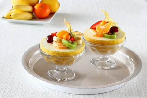Two half Galia melon filled with summer fruits Stock Photos