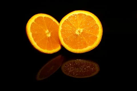 Two  half orange isolated on black with reflections Foto stock