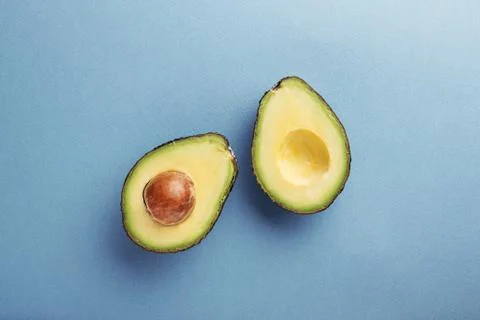 Two halfs of avocado with seed. Stock Photos