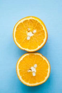 Two halfs of oranges on blue background Stock Photos