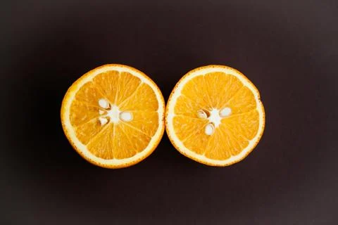 Two halfs of oranges on brown background Stock Photos
