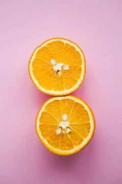 Two halfs of oranges on pink background Foto stock