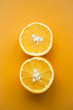 Two halfs of oranges on yellow background Stock Photos