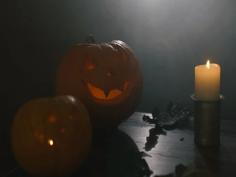 Two Halloween pumpkins head jack lantern with burning candles over black Stock Footage 80245940