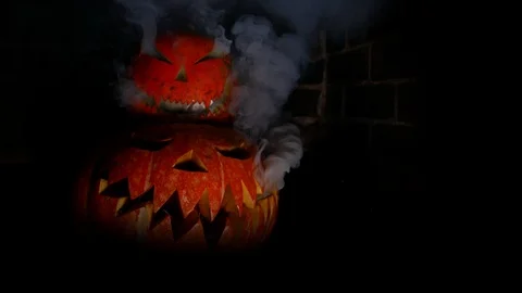 Two Halloween pumpkins on top of each other. Smoke is pouring out of the eye. Stock Footage 116893042