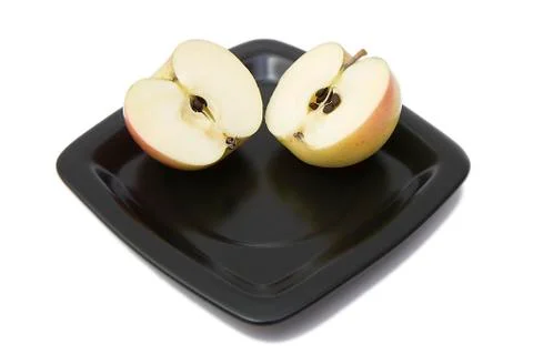 Two halves of an apple on a plate Stock Photos