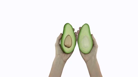 Two halves of avocado, held on white background Vidéo 71628642