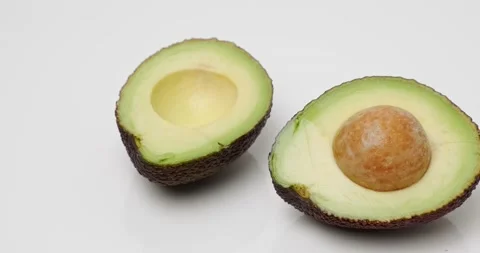 Two halves of avocado with a stone Stock Footage 227039897