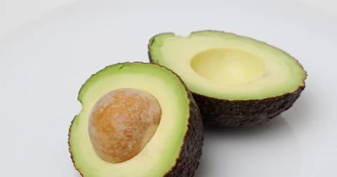 Two halves of avocado with a stone Stock Footage 227040282
