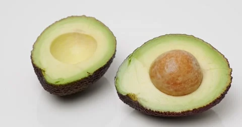 Two halves of avocado with a stone Stock Footage 227040410