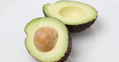 Two halves of avocado with a stone Stock-Footage 227041187