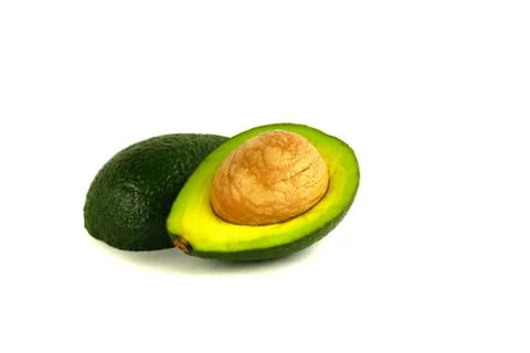 Two halves of avocado with a stone Stock Photos