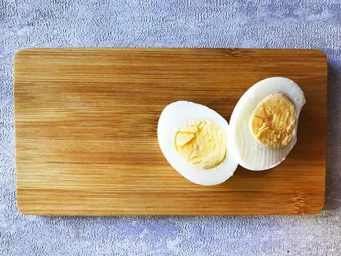Two halves of a boiled egg on a board. Foto stock
