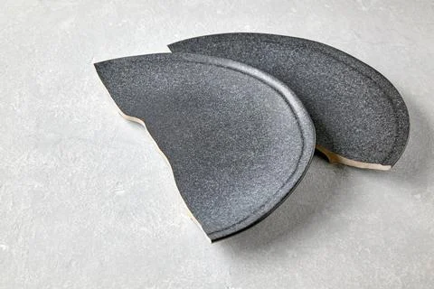 Two halves of a broken ceramic plate on a gray concrete table Stock Photos
