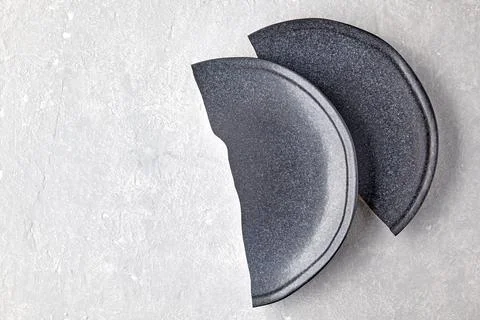 Two halves of a broken ceramic plate on a gray concrete table Stock Photos