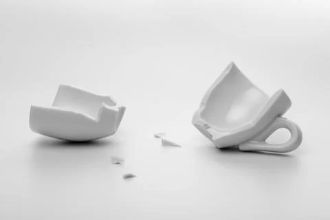Two halves of broken white cup with few little pieces, concept accident, mock Fotos Stock