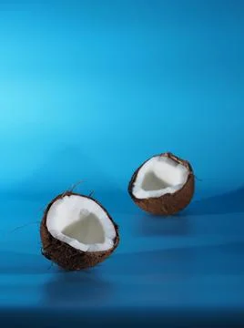 Two halves of coconut on a blue background Foto stock