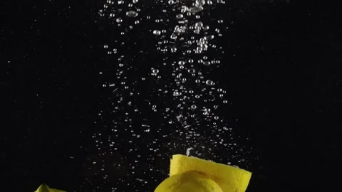 Two halves of fresh lemons sinking deep into water with splashes against black 動画素材 293086086