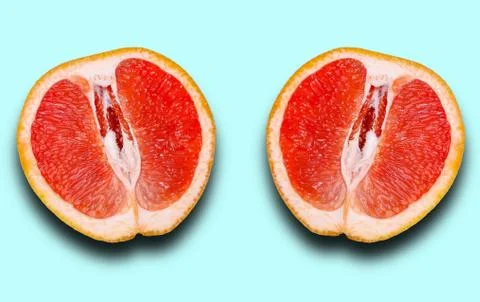 Two halves of grapefruit with shadow isolated on a light blue background. Stock Photos