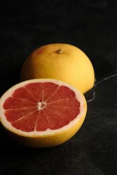 Two halves of greyfruit on a dark background Stock-Fotos