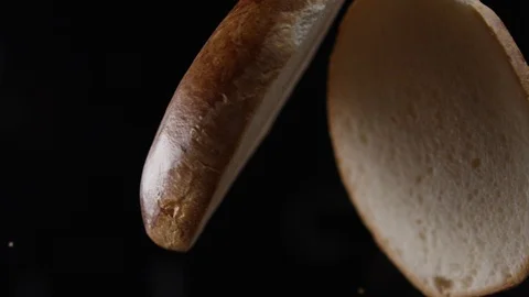 Two halves of a hamburger bun fly up Stock Footage 90883693