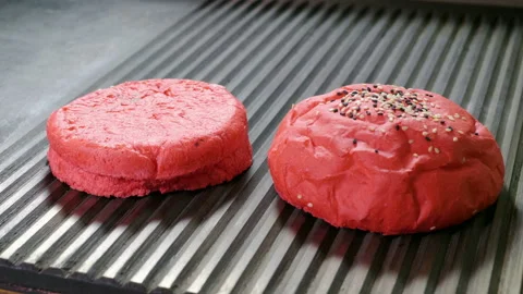 Two halves of hamburger red bun are being fried in a broiler pan for burger. 4K Stock Footage 98023703
