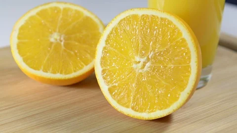 Two halves of juicy orange on the table. A glass of orange juice. Stock Footage 124084080