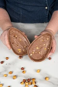 Two halves of a milk chocolate Easter egg filled with hazelnut cream vertical Stock Photos