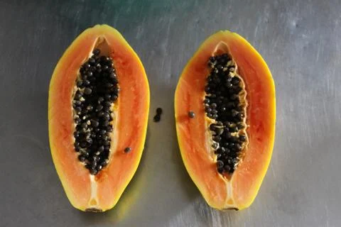 Two halves of papaya fruit on the kitchen table. Papaya fruit with black seed Stock Photos