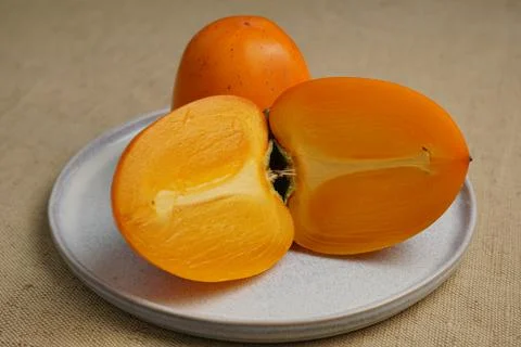 Two halves of persimmon Stock Photos
