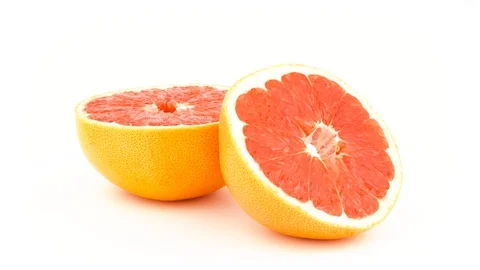 Two halves of a pink grapefruit. Rotating on the turntable. Isolated  Stock Footage 97342382