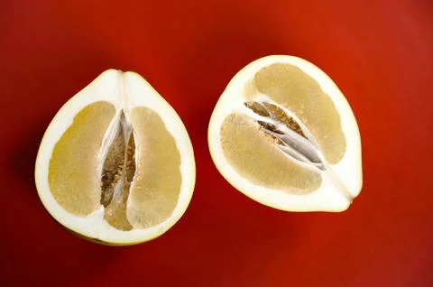 Two halves of pomelo on a red background Stock Photos