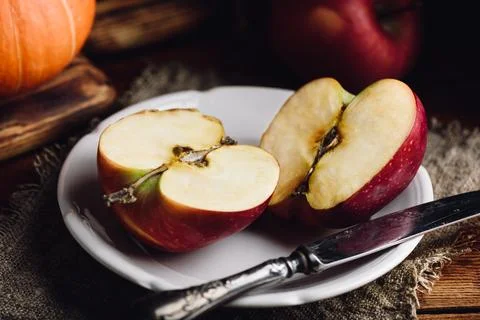 Two Halves of Red Apple on White Plate Stock Photos
