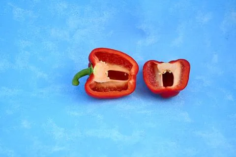 Two Halves of a Red Bell Pepper with Seeds Facing Up on Blue Background Stock Photos