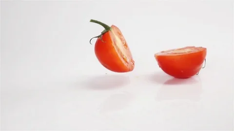 Two halves of tomato breaks hitting white surface Stock Footage 75985676