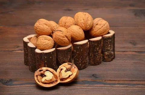 Two halves of walnut and nuts on a wooden table Stock Photos
