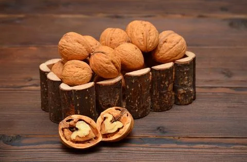 Two halves of walnut and nuts on a wooden table Stock Photos