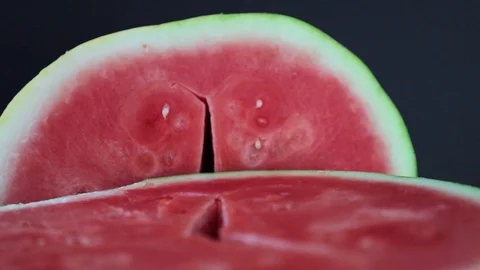 Two halves of watermelon spin on a black background Stock Footage 113933224