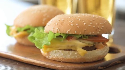 Two hamburger with fresh vegetables and beer glasses. 動画素材 85417258