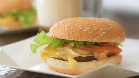 Two hamburger with fresh vegetables and beer glasses. Stock Footage 85417766