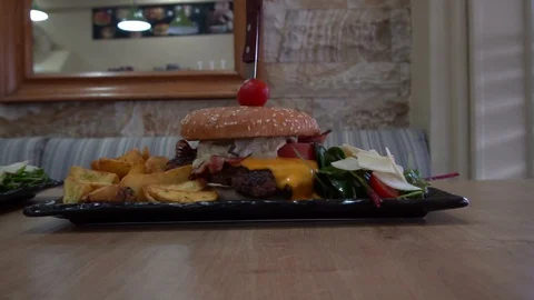 Two hamburger with salad and roasted potatoes on table Video stock 129139650