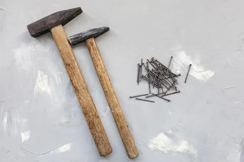 Two hammers and old rusty nails on gray background Stock Photos