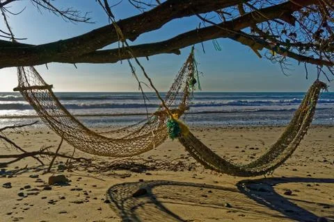 Two hammocks on the beach in the evening sunlight Stock Photos